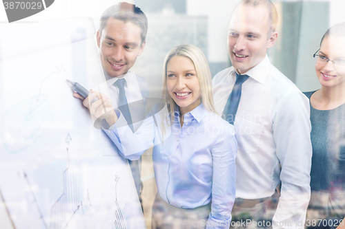 Image of business team with flip board having discussion