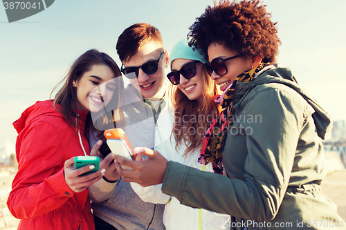 Image of smiling friends with smartphones