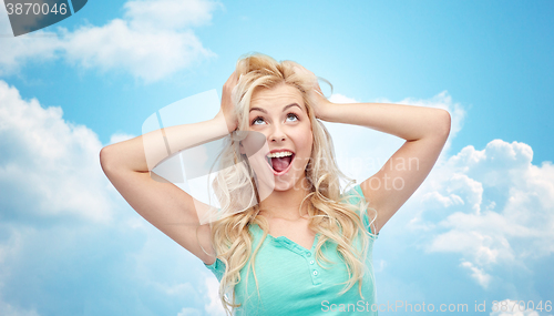 Image of smiling young woman holding to her head or hair