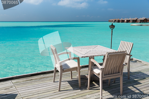 Image of outdoor restaurant terrace with furniture over sea