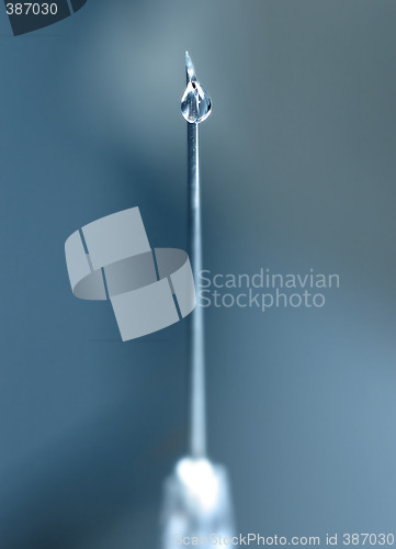 Image of syringe close-up, focus on the drop