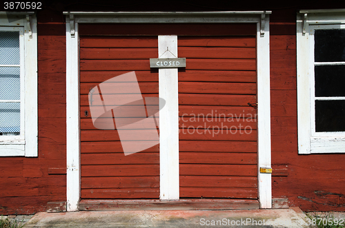 Image of Old red doors with closed sign