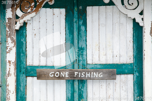 Image of Gone fishing sign at weathered doors