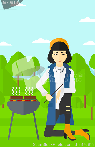 Image of Woman preparing barbecue.