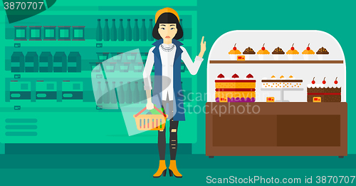 Image of Woman holding supermarket basket.