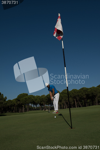 Image of golf player hitting shot at sunny day