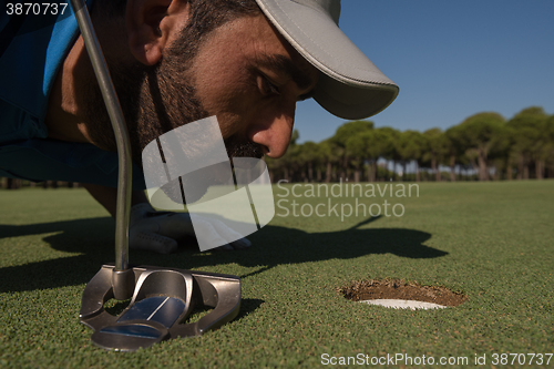 Image of golf player blowing ball in hole