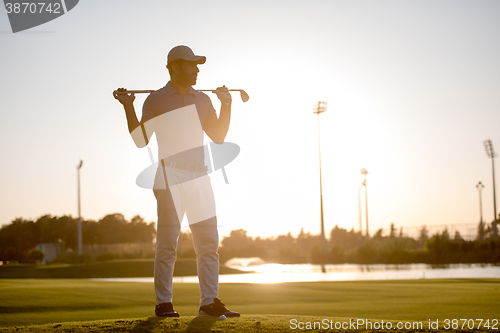 Image of golfer  portrait at golf course on sunset