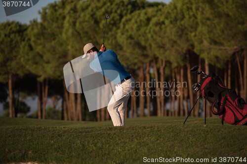 Image of golfer hitting a sand bunker shot on sunset