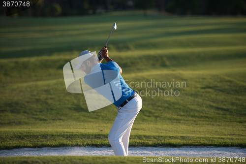 Image of golfer hitting a sand bunker shot on sunset