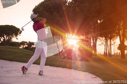 Image of golfer hitting a sand bunker shot on sunset