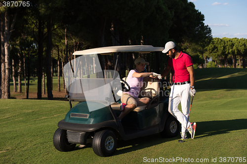 Image of couple in buggy on golf course