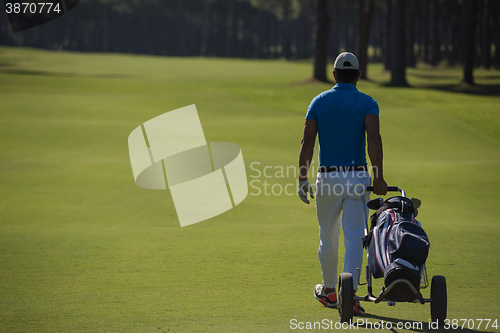 Image of golf player walking with wheel bag