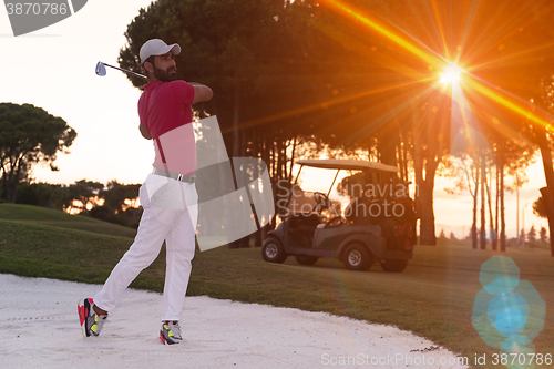 Image of golfer hitting a sand bunker shot on sunset