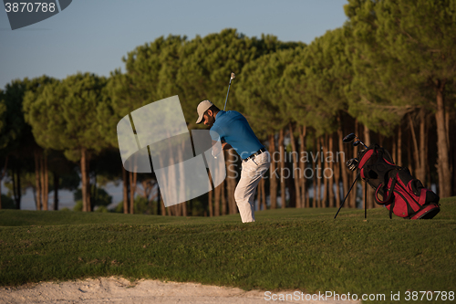 Image of golfer hitting a sand bunker shot on sunset