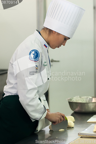 Image of Girl-cook prepares food in competition