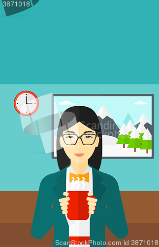Image of Woman sitting with cup of coffee.