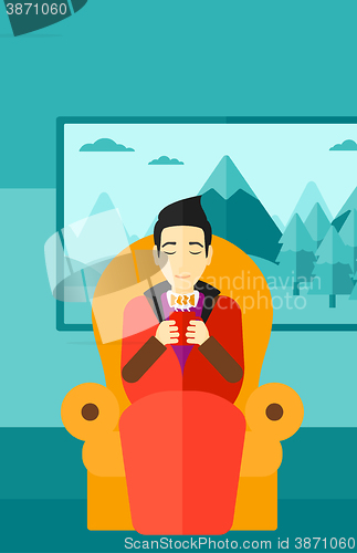 Image of Man sitting in chair with cup of tea.