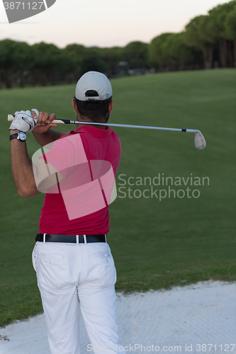 Image of golfer hitting a sand bunker shot on sunset