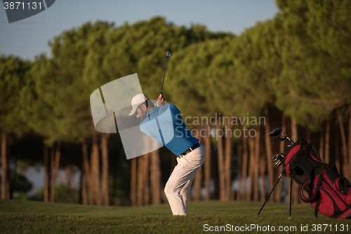 Image of golfer hitting a sand bunker shot on sunset