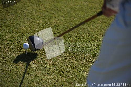 Image of top view of golf club and ball in grass