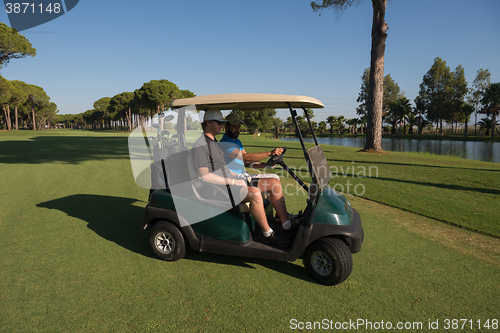 Image of golf players driving cart at course