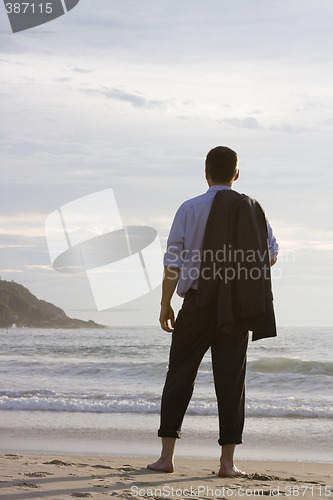 Image of Businessman barefoot on beach