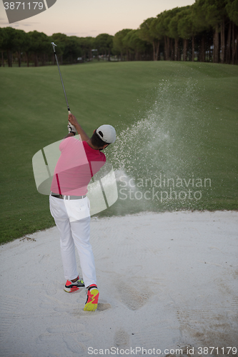 Image of golfer hitting a sand bunker shot on sunset