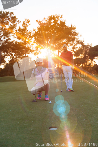 Image of couple on golf course at sunset