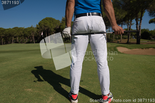 Image of golf player close up hand and driver from back
