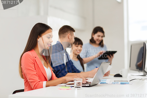 Image of happy african woman over creative team at office