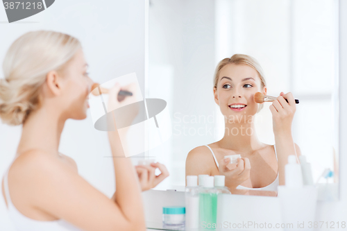 Image of woman with makeup brush and powder at bathroom
