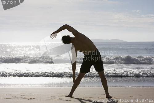 Image of Man doing exercises on beach