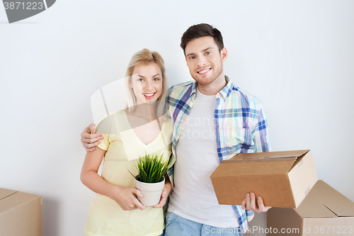 Image of smiling couple with big boxes moving to new home