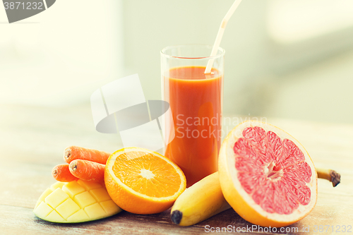 Image of close up of fresh juice glass and fruits on table