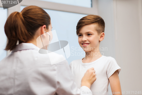 Image of doctor with stethoscope listening to happy child