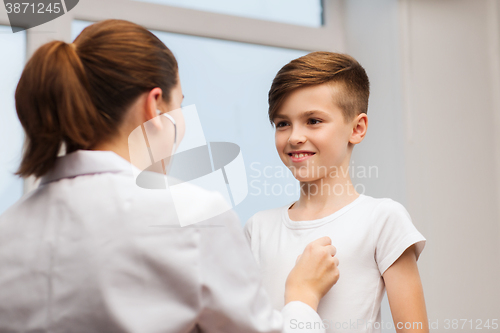 Image of doctor with stethoscope listening to happy child