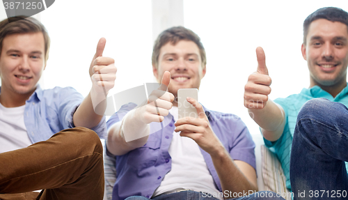 Image of friends with smartphones showing thumbs up 