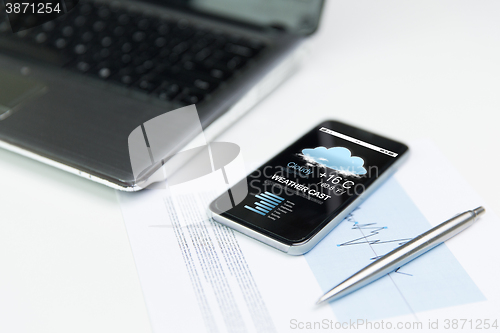 Image of close up of smartphone with weather cast on screen
