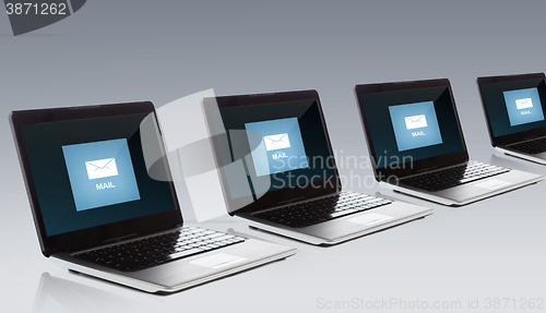 Image of laptop computers with email message icon on screen