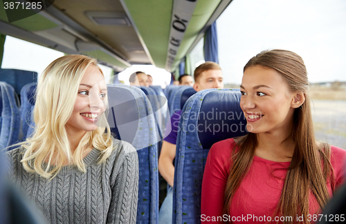 Image of happy young women talking in travel bus