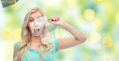 Image of happy young woman with magnifying glass