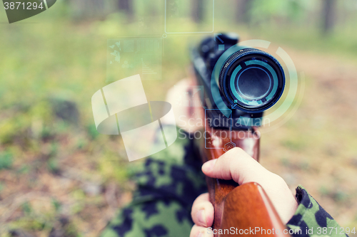 Image of close up of soldier or sniper with gun in forest