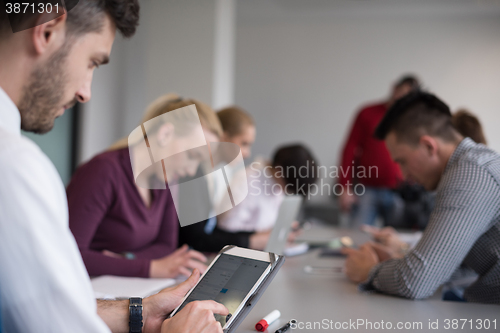 Image of close up of  businessman hands  using tablet on meeting