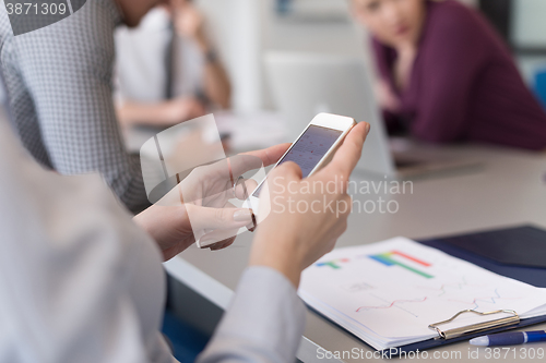 Image of close up of  busineswoman hands  using smart phone on meeting