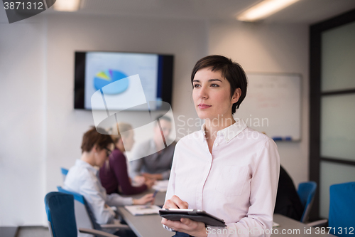 Image of hispanic businesswoman with tablet at meeting room