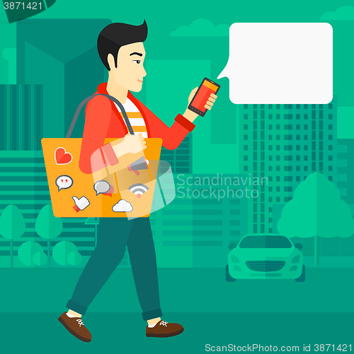 Image of Man walking with smartphone.