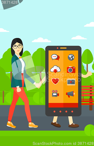 Image of Woman walking with smartphone.