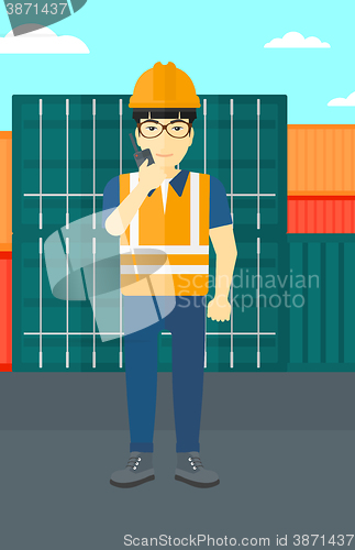 Image of Stevedore standing on cargo containers background.