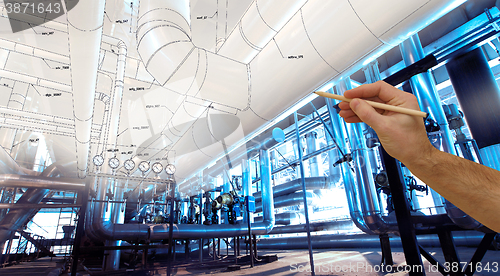 Image of man\'s hand draws a design of factory combined with photo of mode